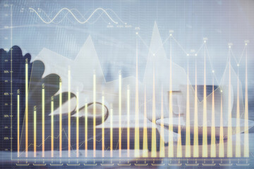 Double exposure of financial chart drawing and desktop with coffee and items on table background. Concept of forex market trading