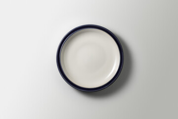 beautiful white plate with blue border on white background, top view