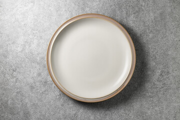 beautiful white plate on gray concrete background, top view
