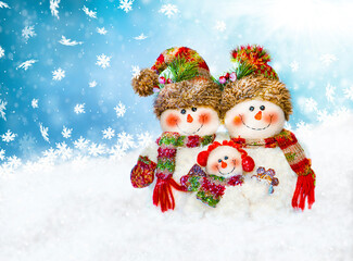 
Christmas greeting card three snowmen on a blue background.