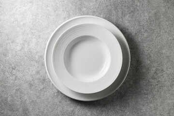 two beautiful white plates on a gray concrete background, top view
