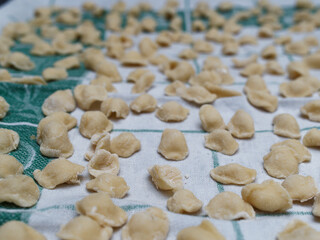 Dinner time at home with the family. On a tablecloth numerous orecchiette, a typical product of southern Italian cuisine.
