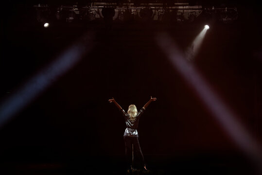 A Young Woman Singer On Stage During A Concert View From The Back.