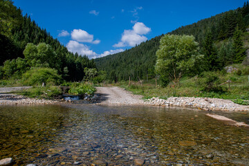 A clear water river with visible little stones between mountain peaks in Bulgaria. Beautiful nature landscape 