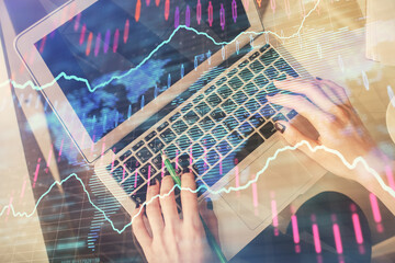 Double exposure of woman hands working on computer and forex chart hologram drawing. Top View....