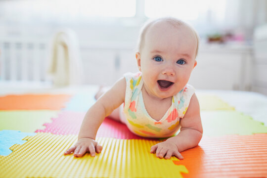 Smiling Baby Girl Lying On Play Mat