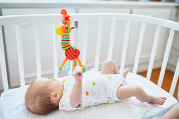 Adorable baby girl lying in the crib