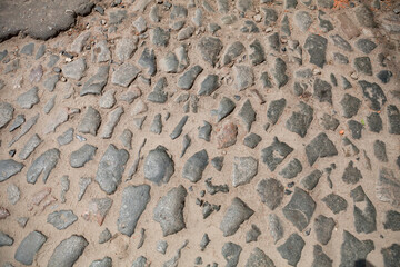 Fototapeta na wymiar The texture of an old stone paved road