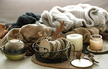 Still life of home decor details, candles, rope and warm clothes in the background