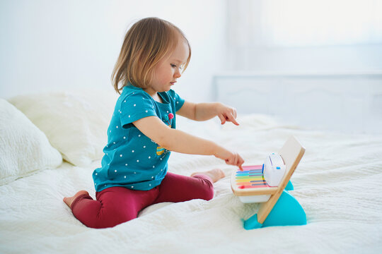 Girl playing toy piano at home