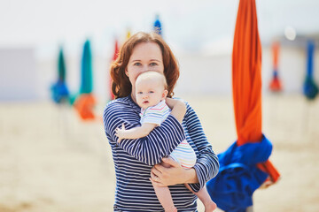 Fototapeta na wymiar Woman and little baby girl on the beach
