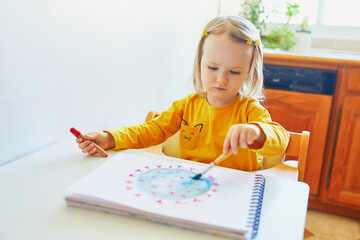 little girl drawing coronavirus with colorful aquarelle paints