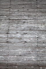 The texture of the old plank wall with the remains of white paint