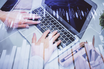 Multi exposure of woman hands typing on computer and forex chart hologram drawing. Stock market analysis concept.