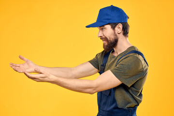 Worker man in uniform worker service yellow background emotion