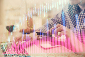 Double exposure of man hands holding a credit card and Forex graph drawing. Stock trading and digital fintech in Internet E-commerce concept.