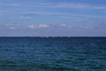 Fototapeta na wymiar blue sea water wave panoramic horizon view with boats and sky with clouds 