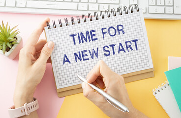 Time for a new start text in notepad on wooden table