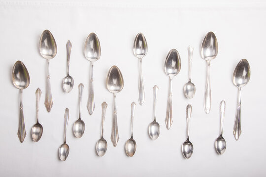 silver spoons on a white tablecloth, tablespoons and teaspoons