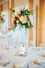 A beautiful vase of flowers on a table in a luxury restaurant. Wedding decorations