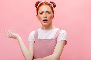 Green-eyed pink-cheeked woman wearing white T-shirt and pink dress is looking indignantly at camera