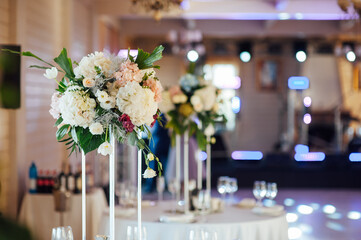 A beautiful vase of flowers on a table in a luxury restaurant. Wedding decorations