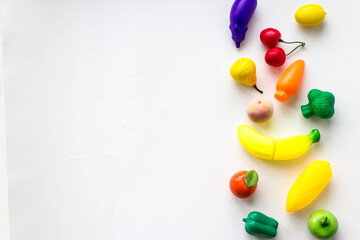 Mini toy vegetables and fruits on white background. Concept of healthy fresh vegetables. creative...