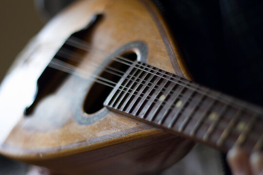 Old hands playing a mandolin