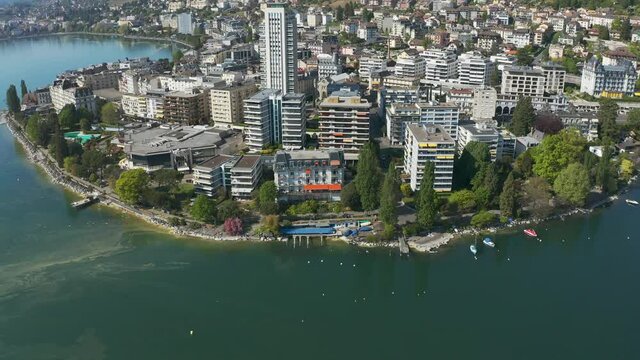 aerial shoot view of the city of Montreux located between the high hills and the lake against the bright blue cloudless sky Switzerland
