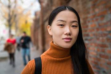 Portrait of young Asian woman in the street.