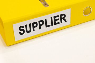The word supplier on a white background with a yellow folder. Business concept