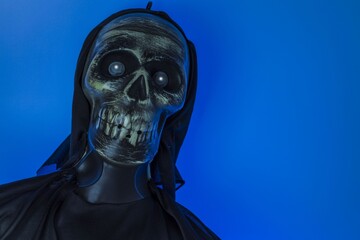 Close up view of blue lighted skeleton head on black background. Halloween concept.