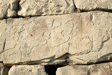 Ancient petroglyphs on the stone walls of an old house, drawings on stones Russia Dagestan
