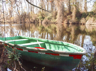 Green canoe morred to the shore © Joi High