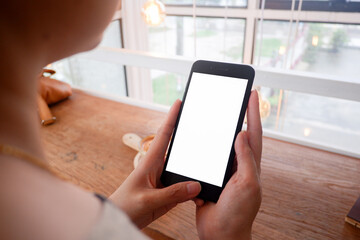 Mockup picture of business woman’s hands/man's hands holding smart phone with white blank screen in modern place.