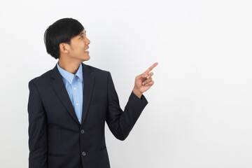 Young handsome asian business man pointing to the side with hand to present product isolated on white background.