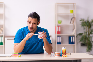 Young male dentist working in the clinic