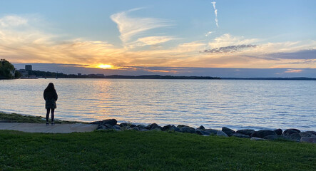 woman walks sunset lakeside lake path ducks
