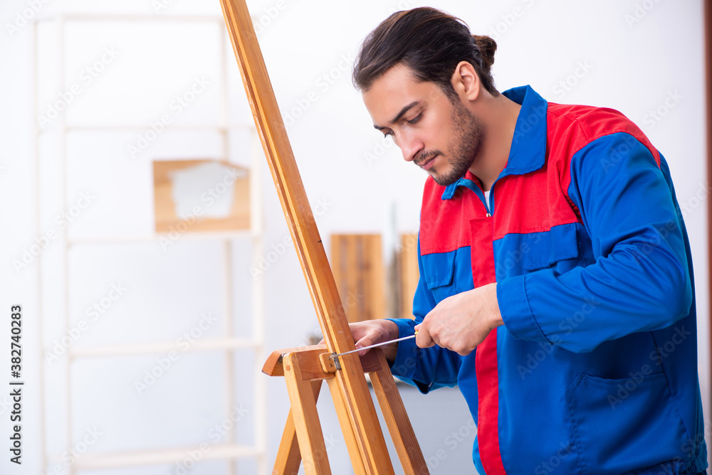 Wall mural Young male contractor working in workshop