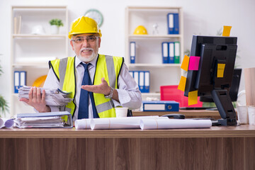 Old male architect working in the office