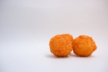 Three fried fish balls on a white background. Side view of fish balls.