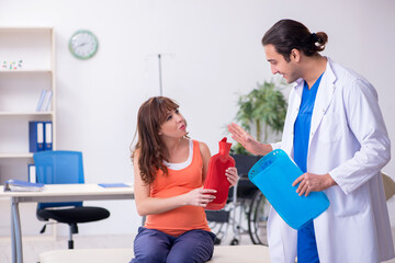 Fototapeta premium Pregnant woman visiting male doctor gynecologist