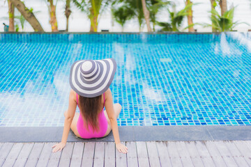 Fototapeta na wymiar Portrait beautiful young asian woman smile relax around outdoor swimming pool in resort