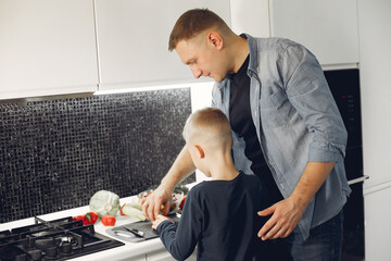 Family in a kitchen. Father with little son. People with vegetables