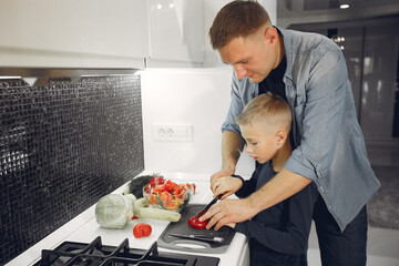 Family in a kitchen. Father with little son. People with vegetables