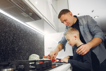 Family in a kitchen. Father with little son. People with vegetables