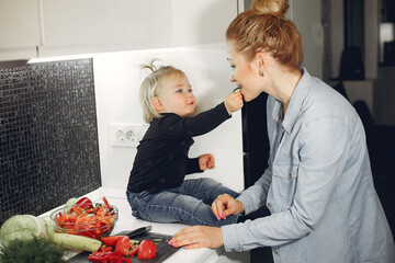 Family in a kitchen. Mother with little daughter. People with vegetables