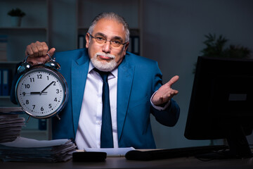 Old male employee working late in the office