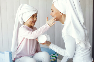 Little girl in a towel. Mother with daughter at home.