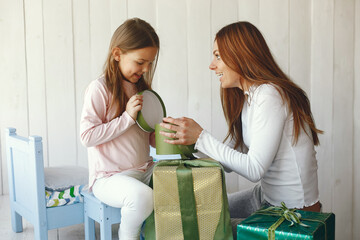 Beautiful woman with child. Woman in a white sweater. Little daughter with presents.